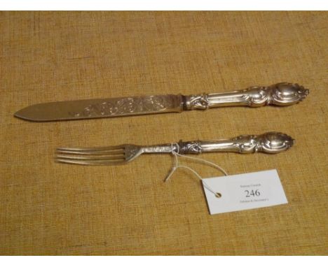 A mid-Victorian silver cake knife and fork, Birmingham 1861 and 1862, with silver blade and tines, the handles cast with roco