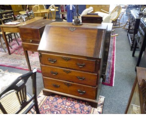 A small George III mahogany slant front bureau, the slope enclosing a fitted interior over three long graduated drawers, rais