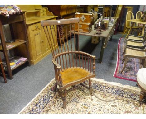 An early 19th century comb back Windsor armchair, probably Scottish, with outswept arms flanking a serpentine seat, on splaye