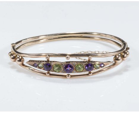A 9ct gold bangle set with amethyst and peridot