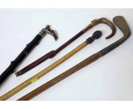 Walking stick topped with a jockey's head, another topped with a nude lady, a riding crop and a golf club. Condition report: 