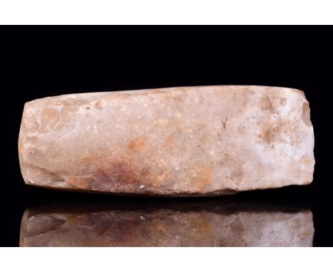 Ca. 4th - 2nd Millennium BCA thick-butted axe head made of light cream flint. With an elongated trapezoid outline and convex 