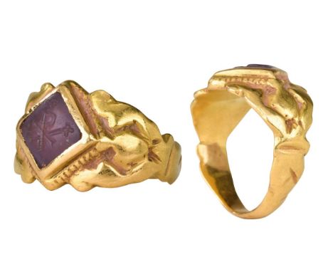 Ca. 600 ADA gold finger ring of a flat-section hoop with wide, supportive shoulders. The bezel set with an amethyst intaglio 