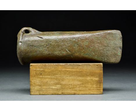 Ca. 800-600 BCAn axe head with a short blade, elongated cylindrical cheek, projecting loop handle, and collared socket.Size: 