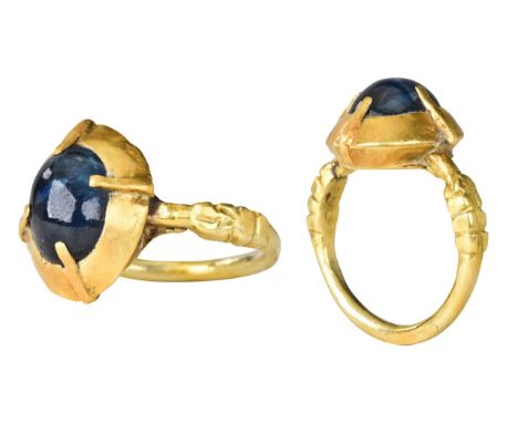 Ca. 1600 ADA gold thin band with ridged shoulders, a large conical shaped bezel with sapphire, held by four gold planks holdi