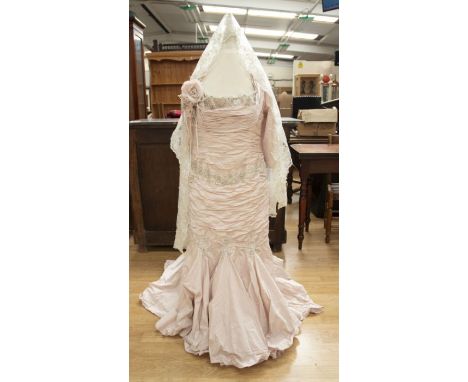 An Ian Stuart shell pink ballgown, the neckline is rushed in the boat neck design, the edging is in crystal beads, and sequin