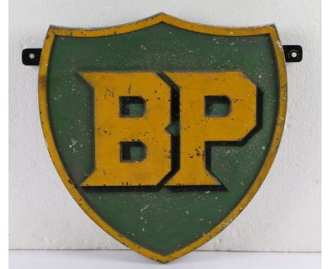 Cast metal BP sign, of shield form with raised yellow lettering on a green ground with raised yellow border, 36cm x 37cm