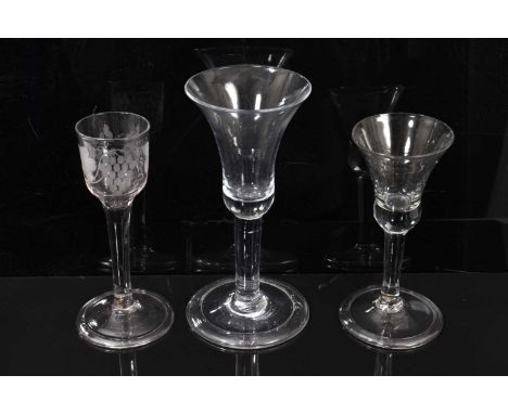 Three mid 18th century wine glasses, including two with bell bowls and one with a vine-engraved ogee bowl, all on plain stems
