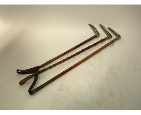 Three antique hunting whips with white metal collars and bamboo shafts with antler handles