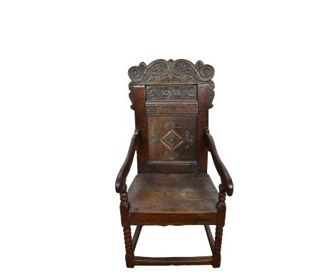 Charles II oak wainscot chair, carved panel back and solid seat on bobbin turned legs united by square stretchers. Provenance