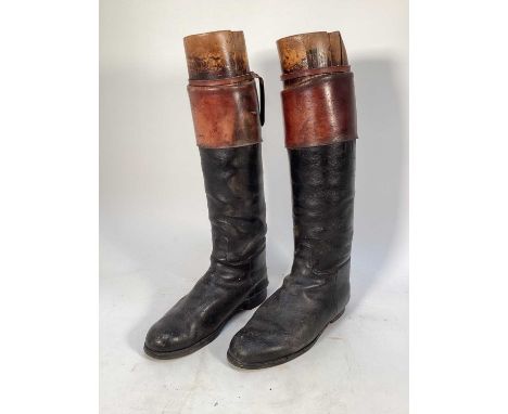 Pair of vintage leather hunting boots with brown tops and wooden trees