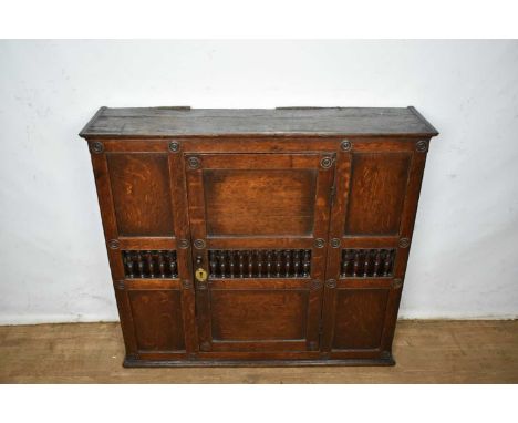 17th century style oak hanging food cupboard, enclosed by panel door with bobbin colonnades and boss ornament, 94cm wide x 25