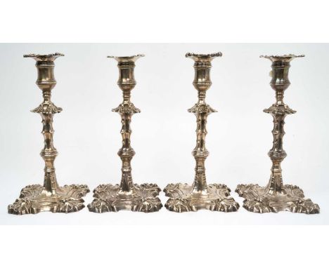 Set of four George II cast silver candlesticks, with slender columns and scroll and claw decoration, separate sconces (London