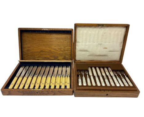 Early 20th century cased set of 12 pairs of fish eaters, with silver plated blades and composite handles, with armorial shiel