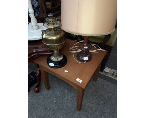 A wooden lamp, a brass oil lamp and a small occasional table 