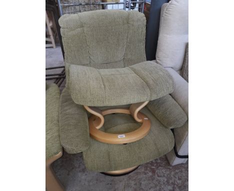 An Ekornes Stressless adjustable armchair in light green upholstery with matching stool. 