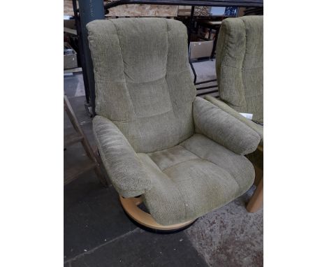 An Ekornes Stressless adjustable armchair in light green cloth upholstery 