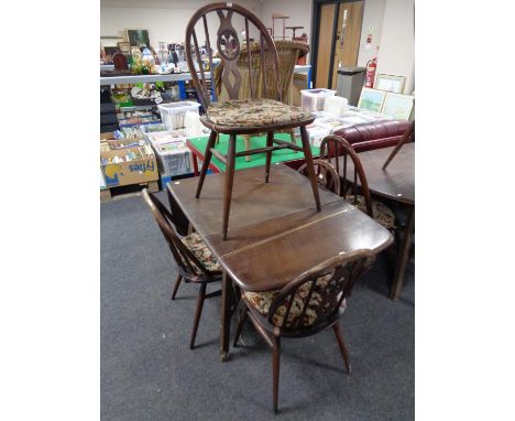 An Ercol stained elm drop leaf rectangular dining table together with a set of four spindle back chairs 