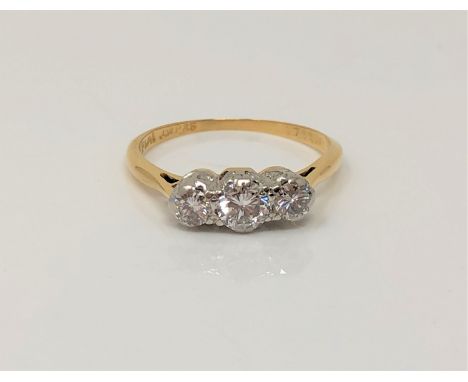 An 18ct gold and platinum three stone diamond ring, centre stone approx. 0.25 carat, size O CONDITION REPORT: 3.1g Total appr