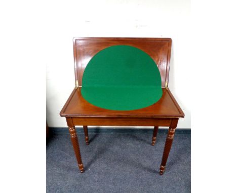 A reproduction mahogany turnover top card table