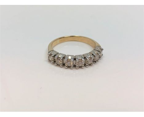 An 18ct white gold seven stone diamond half eternity ring, approximately 0.7ct, size P.