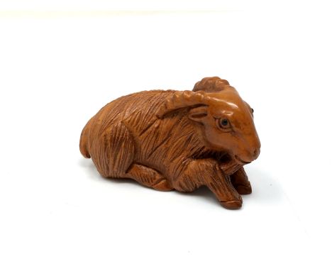 A carved Chinese hardwood netsuke - Goat lying down