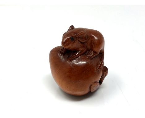 A carved Chinese hardwood netsuke - Rat seated on a peach