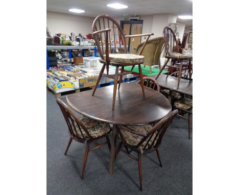 An Ercol stained elm drop leaf dining table together with a set of four spindle back armchairs 