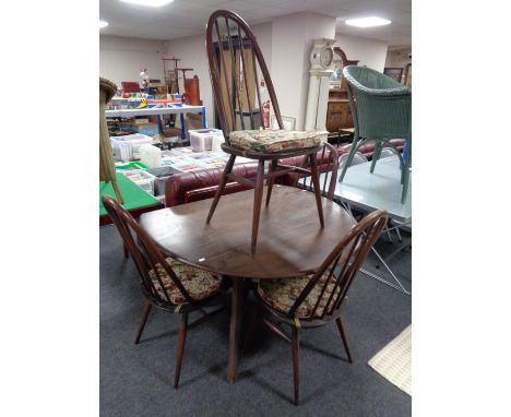 An Ercol stained elm drop leaf dining table and a set of four high back spindle dining chairs 