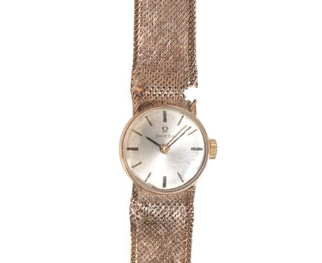 OMEGA: A LADY'S 9CT GOLD WRISTWATCHwith a manual wind movement, the silver dial with applied baton hour markers, on a texture