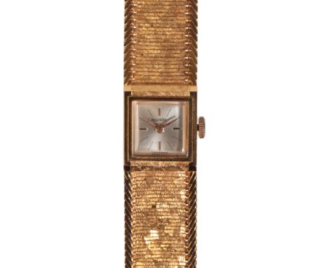 NIVADA: A LADY'S 18CT GOLD BRACELET WATCHwith manual wind movement, the silver dial with gold baton numerals and hands, circa