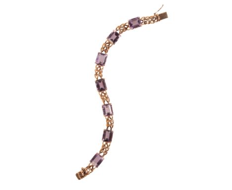 A VINTAGE AMETHYST BRACELETin 18ct gold, comprising a series of stylised links, set throughout with step cut amethysts totall