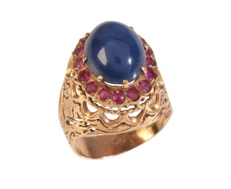 A SYNTHETIC STAR SAPPHIRE AND RUBY BOMBÉ RINGin 9ct gold, set with a synthetic star sapphire in a border of synthetic rubies 