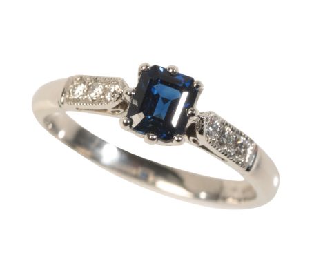 A SAPPHIRE AND DIAMOND RINGin platinum, set with a step cut sapphire, leading to sweeping diamond set shoulders, full British