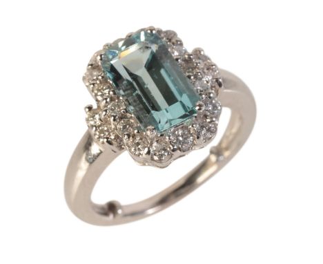AN AQUAMARINE AND DIAMOND CLUSTER RINGin 18ct white gold, set with a step cut aquamarine of c.2.35 carats in a border of roun