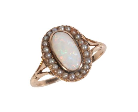 AN ANTIQUE OPAL AND PEARL CLUSTER RINGin 9ct gold, set with an opal cabochon measuring 10.7x5.3x1.9mm, held in a rubover sett