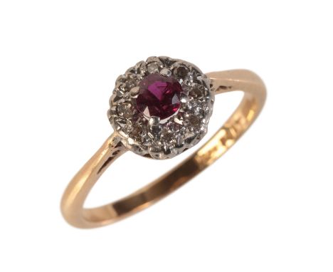 A VINTAGE RUBY AND DIAMOND CLUSTER RINGin 18ct gold and platinum, set with a round cut ruby of c.0.35 carats in a cluster of 