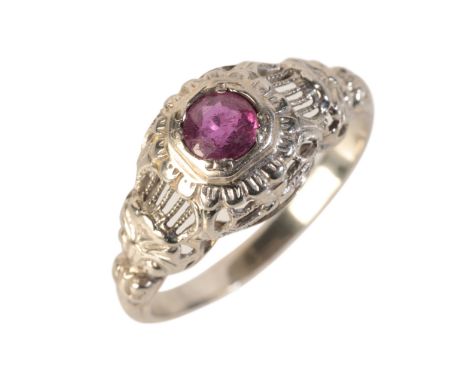 A RUBY DRESS RINGin 18ct white gold, set with a round cut ruby of c.0.40 carats, held in a rubover setting to stylised openwo