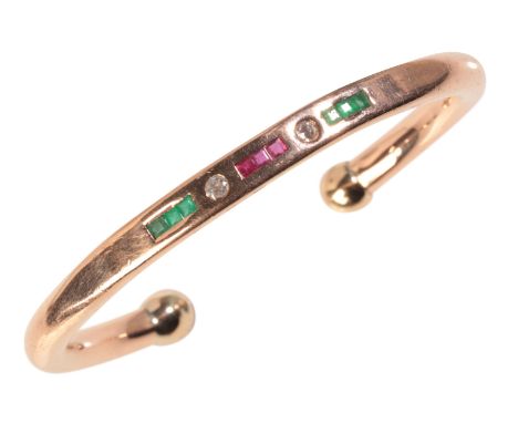 A GEM-SET CUFF BANGLEin 9ct gold, set with step cut rubies and emeralds, alternating with two old mine cut diamonds, full Bri