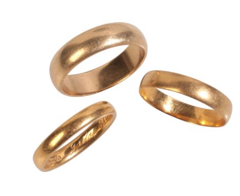 THREE GOLD WEDDING BANDSincluding two in 22ct gold, the first 3.8mm wide, full British hallmarks for Birmingham, 1887, UK siz