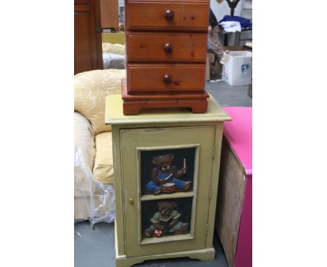 A painted cupboard unit, the panelled door carved in relief with a bear playing the drums and a bear playing with a ball, 64c