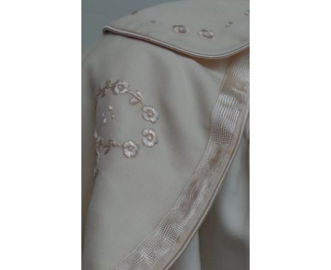 An Edwardian childs cloak. Cream silk lined with embroidered panel to back with a silk tie fastening. Nice condition