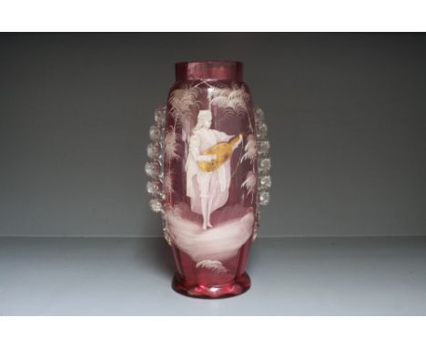 A large Victorian Mary Gregory style cranberry glass vase decorated with a man playing the guitar 30cmH