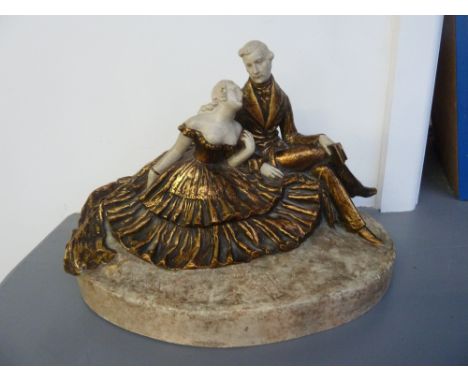 A an early 20th century Czech figurine group of a man and woman in eveing dress sat on earth from base, signed K. Pan 1912