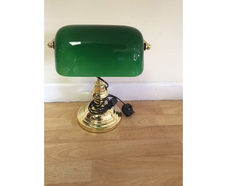 A brass bankers lamp with green shade