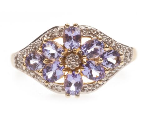 TANZANITE RING, the openwork bezel set with oval faceted stones around a central cluster of diamonds, within a diamond border