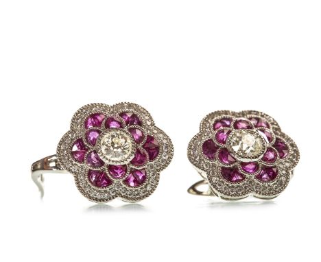 PAIR OF RUBY AND DIAMOND EARRINGS, each in the form of a floral motif 17mm wide, with a central round brilliant cut diamond o