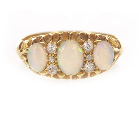 OPAL AND DIAMOND RING, the boat shaped setting with three graduated oval cabochon opals interspaced by diamonds, in eighteen 