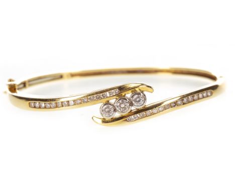 DIAMOND SET BANGLE, set centrally with three round brilliant cut diamonds totalling approximately 0.45 carats to a twist sett