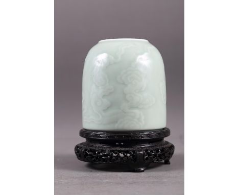 A Chinese celadon glazed brush washer with cloud decoration and six-character mark to base, 4 3/4" high, on associated hardwo